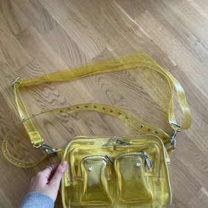 Gul väska från Nunoo - 🌼Säljer en väldigt fin väska från Nunoo. Den är i plast och är genomskinlig vilket är lite kul så där🌼