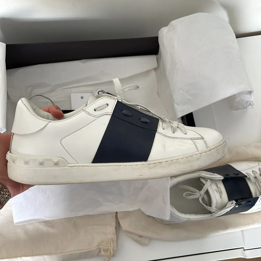 Valentino open sneaker i Mörk blå och vitt, Storlekt 43 och en bra kondition, lite smutsiga, annars är skorna som nya bara lite smutsiga, (går att tvättas). Det medföljer äventyr par  nya skosnören, låda, tygpåsar, (från valentino). Skor.