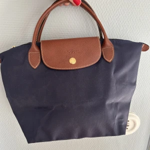 Longchamp väska - Säljer denna super söta longchamp väskan. Knappt använd. Det är den mindre versionen. Köpt för ca 700-900kr lite osäker. 