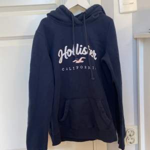 Mörkblå hoodie från hollister med vita och ljusrosa detaljer i storlek xs. (Dock ganska stor i storleken). Knappt använd och i fint skick. Skriv om ni undrar något❤️