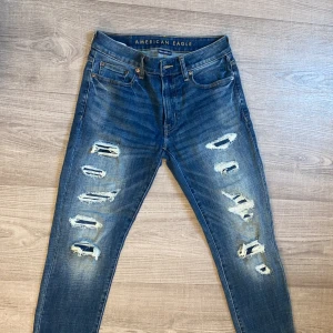 Jeans från American eagles - Mörkblåa jeans med slitningar längst låren ner till knäna. Märket är från american eagles. Hör av dig privat för prisförslag eller fler bilder.