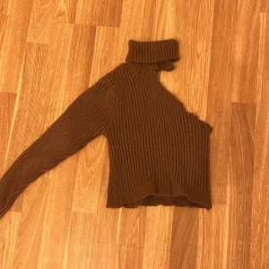 Tröja  - Srickad tröja med polokrage och en arm i storlek xs, aldrig använd 