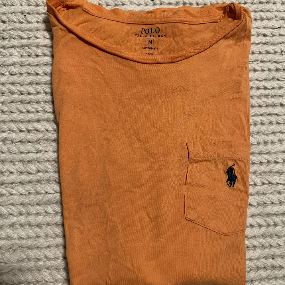 Orange polo Ralph lauren T-shirt. Knappt använd och i gott skick. Nypris ca: 600-700:- OBS: kläderna är skrynkliga då de legat nerpackade.. T-shirts.
