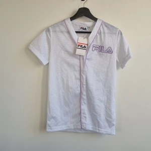 Ny Fila baseballtröja  - Säljer denna underbara baseballtröja från fila, ny med prislapp. Prefekt för våren eller att slänga på sig till gymmet 😄  Den är oversized så passar en xxs-small ( storleken är uk 4) 
