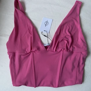 Korsettopp 💗 - Rosa topp som passar perfekt för sommar och fest. Helt ny och oanvänd (lapp finns kvar) säljer pga lite stor på mig. Färgen är lite mer ”levande” i verkligheten, men svårt att få med på bild ✨strl S men skulle säga passar M också 