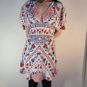 klänning med blommor från Kiss the Sky - en oanvänd klänning med blommönster från Kiss the Sky i storlek L. har band som man knyter vid ärmarna och kan justeras efter preferens. möter ej upp, postar enbart 🌸 