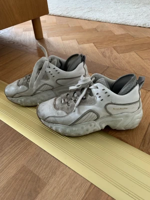 Acne studios sneakers - Vita sneakers från Acne i storlek 36. De är ganska stora i storlek, jag har oftast 37.   Observera att skorna är väl använda. Men det är inget fel på dem. 