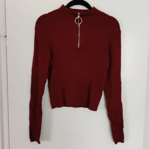 H&M divided tröja strl. M - En varm, hög i nacken, mörkröd tröja med häftig dragkedja i halsen. Den är liten i storleken och lång i armarna, skulle passa någon som vanligtvis har storlek S eller XS. 