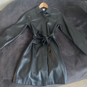 Skjortklänning i fuskläder - Otroligt snygg lite tjockare klänning från MQ. Fuskläder, knappar längs hela och ett bälte i midjan som man kan ta bort. Klänningen är storlek XS och går ner till knäna på mig som är runt 160cm lång. 250kr inklusive frakt