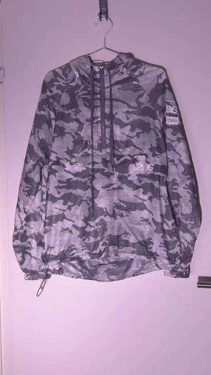 Svea vindjacka  - Svea vindjacka vit/grå cammo med magficka Snöret på luvan behövs bytas ut annars fint skick
