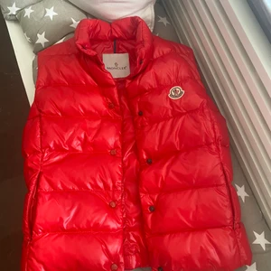 Moncler väst - Säljer min röda moncler väst, då den är blivit lite liten:( Den är i storlek 1, vilket motsvarar small💗Köpt på Kaspersheat, så den är såklart äkta!! Väldigt bra skick då den inte har kommit så mycket till användning. Skriv om du vill ha mer bilder elr så🥰