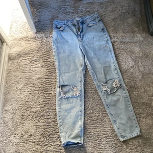 Ett par jeans  - Ett par höga miljard jeans som har hål