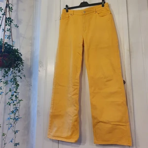 Jeans gula storlek 32/M/L - Gula, vida jeans. Wide legged och highwaisted. Mer eller mindre oanvända och i nyskick. Färgen är lite blekare i verkligheten, här på bilderna är de lite för GULA. 