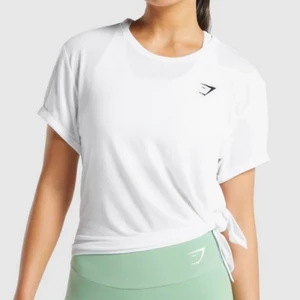 T-shirt - Gymshark - Superskön T-shirt från Gymshark som man kan knyta i sidan. Aldrig använd, i nyskick! Säljer för 150 kr + frakt 🖤