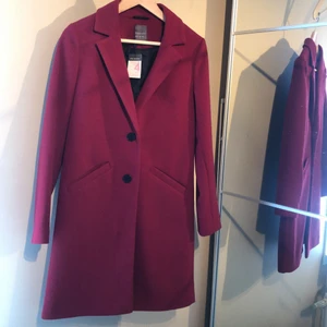 Vinröd kappa från primark i strl 4/32 - Vinröd oanvänd kappa med lapparna kvar i från primark. Storlek 4/32 men sitter mer som en 34 skulle jag säga! 