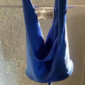 Zara festtopp i satin material  - En blå festlig topp i material satin och med knyte i ryggen. Köpt från Zara  