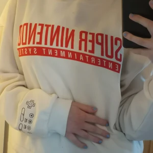 Cropped hoodie / ljus / med tryck - Storlek: S (kvinnlig), använd en gång men det helt ny ut, syns knappt på bilderna men den har trådar man kan dra i längst ner för att göra den tight runt midjan