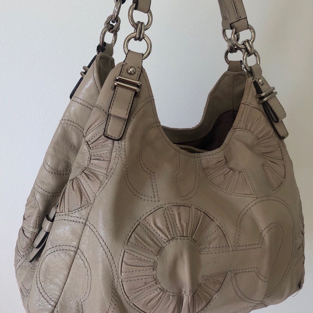 Elegant coach bag in nude colour. The bag has not been used much and is in a very good condition. Includes original dustbag. Shows slight signs of discoloration (e.g. inside handles, visible only on detailed examination). Väskor.