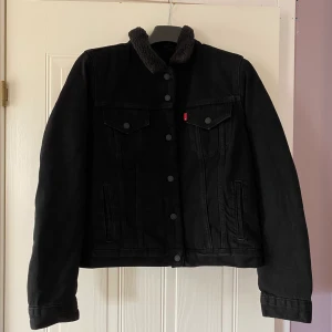 Levis sherpa jacka  - Svart sherpa jacka från Levis i storlek L. Kan mötas upp i Kungsbacka. Katt finns i hemmet. 