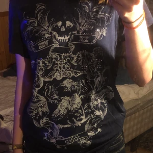 Hm t-shirt  - Blå T-shirt med snyggt tryck å pärlor.