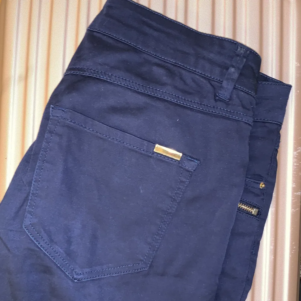 Låga fina byxor i 32or Med guldknapp och kedja. Bra kvalitet och hållbarheten är bra. Jeans & Byxor.
