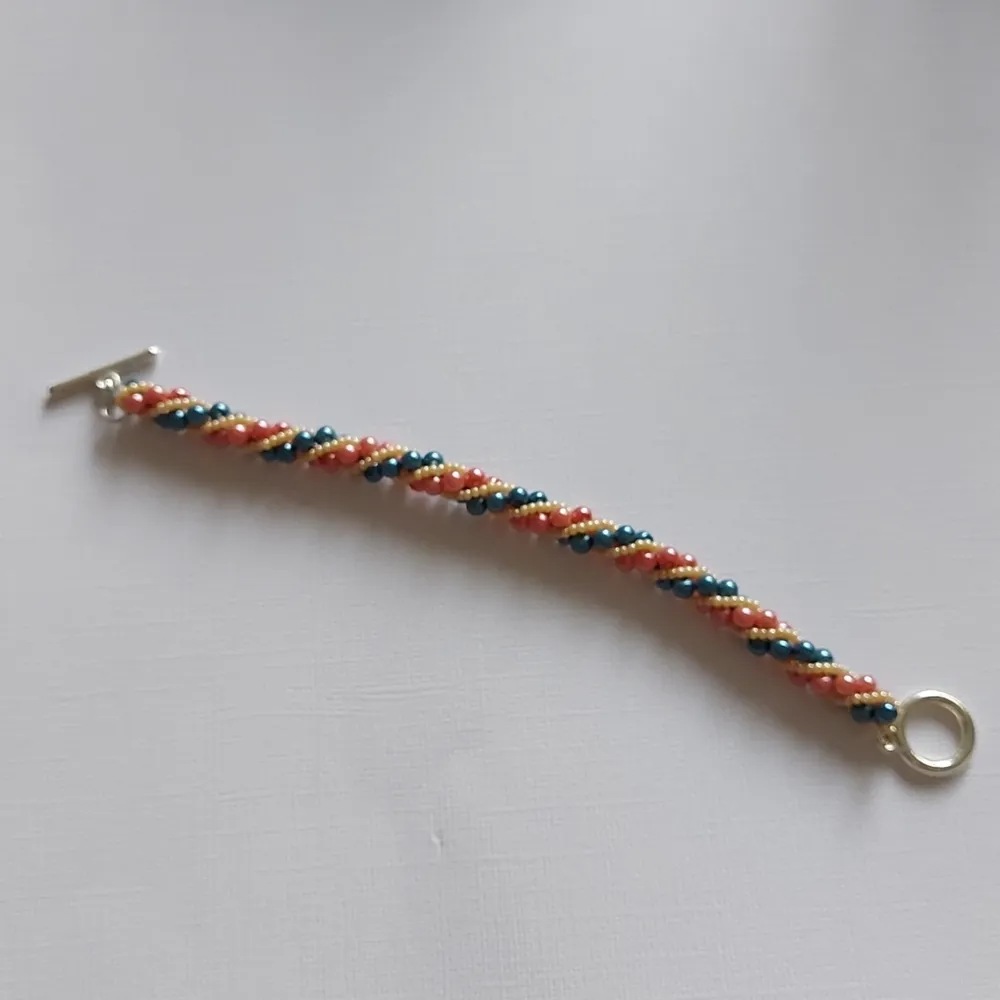 Armbandet är vridet Pärlor av pärlemor och miyuki seed beeds med togglelås  17cm långt, 8mm brett Egentillverkad med mönster hämtat från Youtube  Frakt 13. Accessoarer.