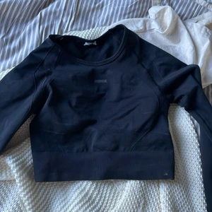 Gymshark topp - Svart gymsharktopp i storlek S. Passar bra även för de med lite mer muskler kring axlar/nacke. Ärmar med tumhål 