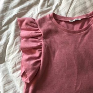 rosa topp - jätte söt topp med volangärmar, nästan oandvänd. väldigt liten i storleken, är som en xs/s