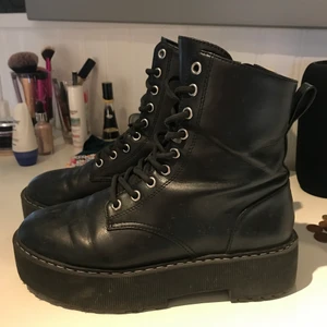 Kängor från H&M - Kängor från H&M med platå.  Kängorna är i konstläder och har snörning fram, dragkedja i ena sidan och hälla bak. Klackhöjd 6 cm.  Använda men fint skick! Storlek 39.  Nypris 349 kr.