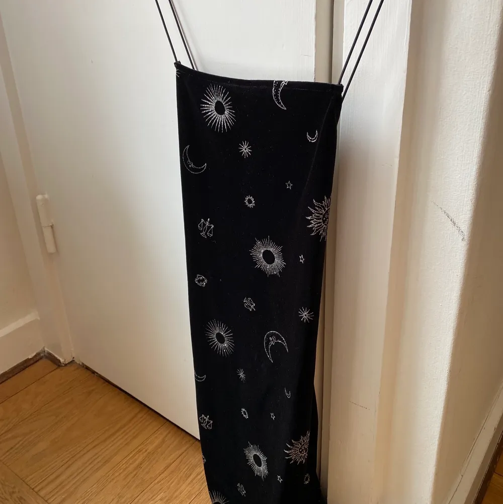 Kort svart klänning i sammet med magiska detaljer i silver. Använd 1 gång. Stretchigt material. Mekot.