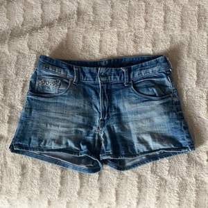Säljer ett par gamla jeansshorts som är lågmidjade i storlek 34. Shortsen har detaljer på bakfickorna. Hör av dig för fler bilder eller om du är intresserad! 