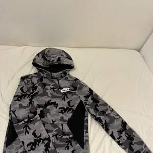 Nike hoodie i svart grå camouflerings färg i storlek L junior (147-158).