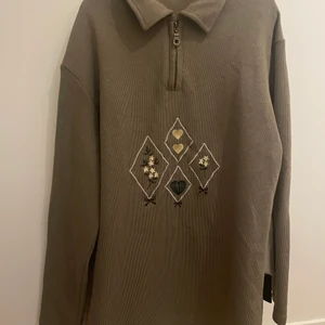 Superfin tröja - Militärgrön tröja med supergulligt broderi och liten dragkedja och krage på framsidan! köpt second hand men aldrig använd av mig och i bra skick!✨✨ passar S/M