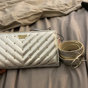 Victoria’s Secret stor-plånbok och skärp - Två silvriga Victoria secret accessoarer, skärpet passar x.small-medium och är i super skick! Köp för 50kr! Plånboken eller den lilla väskan du kan bära för att piffa till din lite finare outfit är helt oanvänd och har fortfarande lapp på! Köp för 100kr eller båda tillsammans för 120kr💗💗 skärpet är superfint över en kjol😍😍