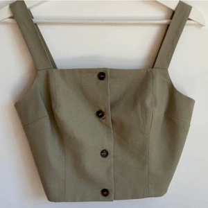 NA-KD topp/linne  - Oanvänd topp från NA-KD i storlek 36. I färgen beige/grön! Knappar i axelbanden för att kunna ändra storleken. Om frakt önskas löser vi det! 