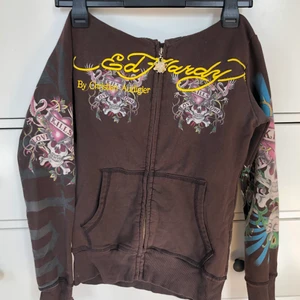 Ed hardy hoodie - lägger ut igen pågrund av att köpare inte svarar. Ed hardy hoodie med rhinestones o tryck på båda armarna, rygg och fram. Den har ett hål i luvan men som man kan sy väldigt lätt.