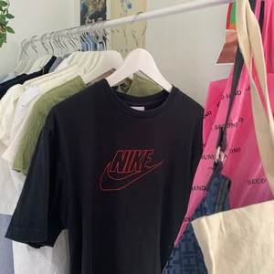 Nike T-shirt  - Svart T-shirt med röd nike logga, limited edition kollektion. Sitter oversized på mig som är S. Skriv vid frågor eller fler bilder ❤️‍🩹 storleken beror på hur man vill att den ska sitta :)