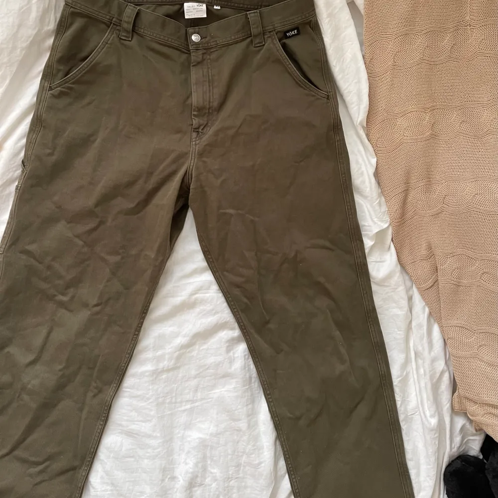 Militär / moss gröna byxor från märket Yoke med sidofack på benet, söta detaljer och mycket sköna i tyget! XL men kanske liiiite små i storlek så skulle säga L / XL. Jeans & Byxor.