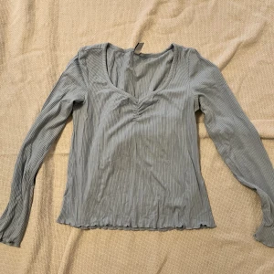 Ljusblå tröja  - En ljusblå tröja från &other Stories som har lite fina detaljer framtill, tröjan är använd fåtal gånger och är därav i väldigt bra skick! 