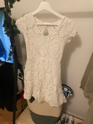 Sommar klänning - Vit mediumkort sommarklänning med blommigt mönster. Jättefin och perfekt för våren. Köpt för ca 2 år sedan och använd Max 3 ggr. Pris kan diskuteras