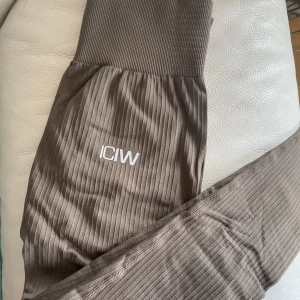 Iciw ribbed define träningstights - Icaniwill ribbed define träningstights i en fin brun färg, ribbat material, storlek xs. Nypris 699, använda en gång. Stretchiga och super sköna! 