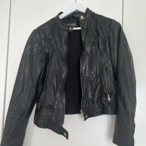 Äkta skinnjacka rockandblue - Skinnjacka i äkta skinn med guld detaljer. Storlek 40. Passar som en storlek 38 eller M. 