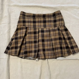 Rutig tenniskjol  - En rutig tenniskjol som påminner om burberry mönstret. Väldigt y2k i stilen och går att klä upp så som ner. 