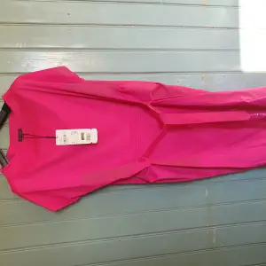Oanvänd Escada klänning i stl 36/38. Trendig Cerise rosafärg. Kan bäras med skärpet i midjan åtdraget eller löst hängande. Perfekt klänning för att synas ordentligt på festen.
