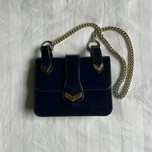 En blå väska med gulddetaljer 💙