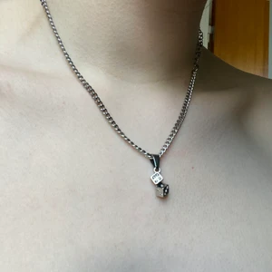 Tärningshalsband från Dalmata - Roll the dice chain från Dalmata. Gjort av rhodium pläterat rostfritt stål, rhodium är allergivänligt. I tärningarna sitter små strasstenar och i slutet av kedjan hänger Dalmatas egna stjärnlogga. I mycket fint skick, inga uppenbara defekter. Kortast längd är ~30cm, längsta 44cm. Nypris 50 USD + tull och frakt. Kan mötas upp på södra sidan av stockholm annars står köparen för spårbar frakt 66kr, kan skicka billigare men ansvarar då EJ för postens slarv! Skriv vid frågor 💌