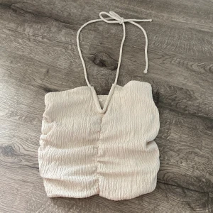 Jättefin beige topp från H&M - Superfin biege topp från hm i jättebra skick och med snören man knyter runt nacken! 