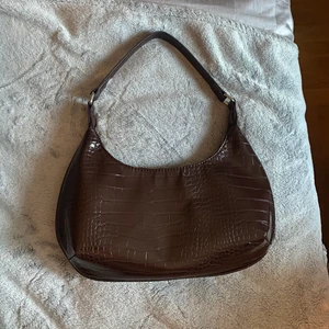 brun väska - köpt på gina tricot för 299kr! fint skick, och fin mörkbrun färg med silvriga detaljer🤎 kommer inte till användning<3 spårbar frakt 51kr