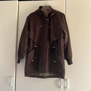 Helt ny brun/mocha jacka, vatten och vindavisande - Säljer en mocha jacka som är vind och vatten avisande 🤎 Passar både till vår och höst. 🍃🍂 Är ”padded” och har snörre runt midjan med gulddetaljer. Köpt i Hong Kong och är aldrig använt, passar därför perfekt som present 😍 Påminner om HM och &OtherStories🤍