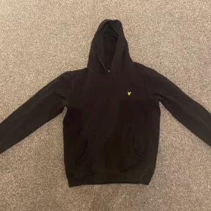 Svart lylescott hoodie  - Säljer denna hoodien då jag inte använder den längre. storlek 146-152 men är absolut minst en xs-s. Inga skador eller likande.  Vet ej vad Originalpris är men jag säljer denna för 100kr. Spårbart - 51 inte spårbart - 62 kr (en M postpåse)